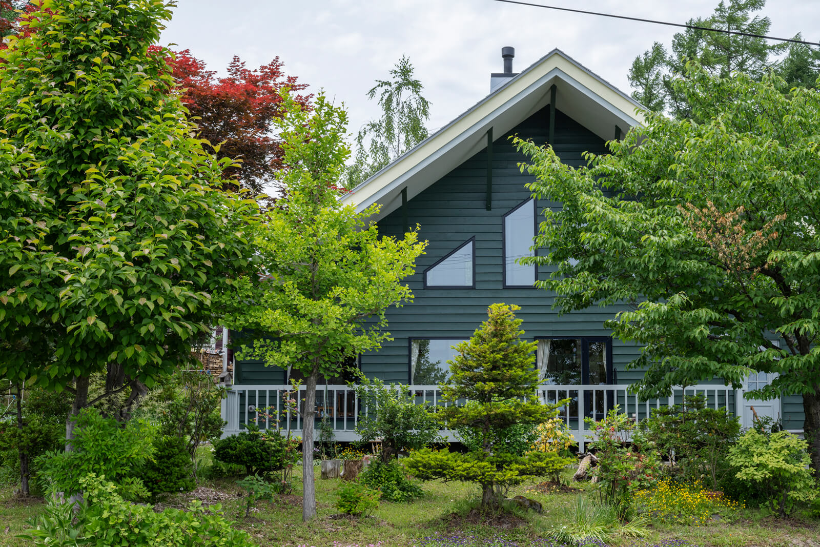 住宅は、三角屋根とグリーンの外壁が目を惹く。Kさんは大手メーカーの元設計士で、この家も自ら設計した