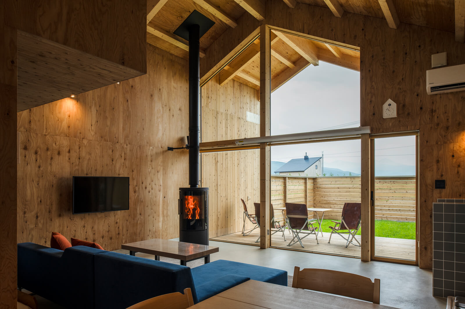 山々の稜線を捉えるダイナミックな窓を背景に佇むHWAM「3630」。冬になると雪景色と揺らめく炎が織りなす北海道らしい風景が楽しめる