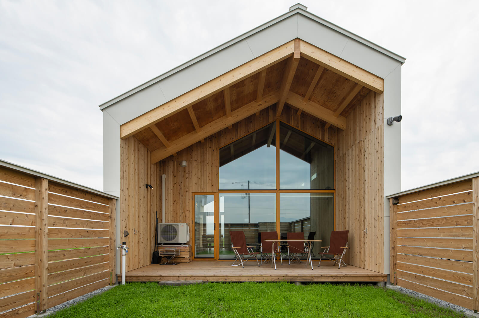 ドッグランは芝生ではなくクローバーを敷き詰めている。日射をコントロールする屋根のあるウッドデッキには近々、薪棚を設置する予定